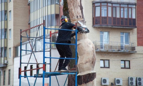 У Дворца спорта в Архангельске художник из цельного куска дерева создаёт поморскую куклу панку